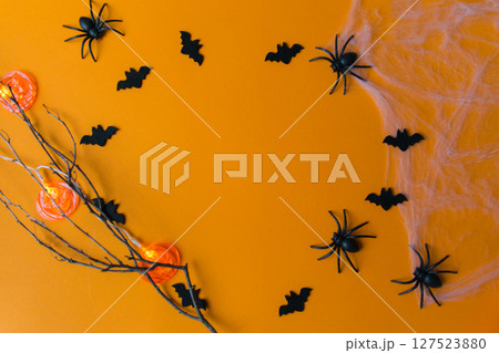 Halloween decorations with pumpkins, bats, web, bugs on orange background. Party greeting card with copy space.  127523880