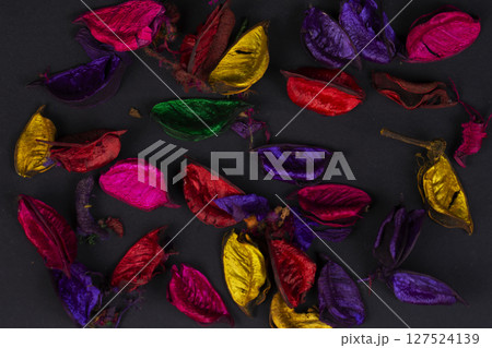 Multi-colored dry petals on a black background. 127524139