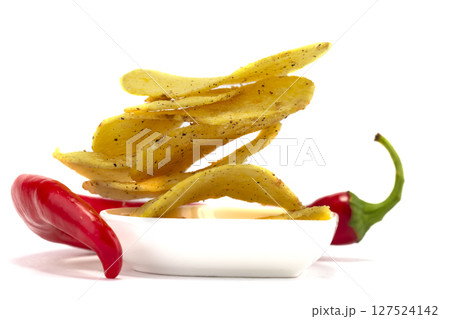 Potato chips with chili peppers on a white background. 127524142