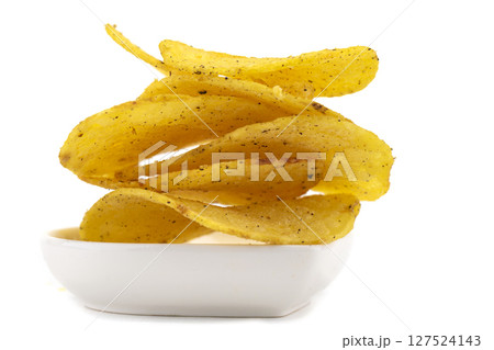 Chips on a white plate are photographed close-up. 127524143