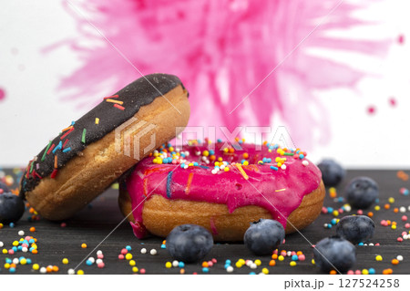 Creative sweet food. Bright donuts with multi-colored sprinkles on a colorful background. 127524258