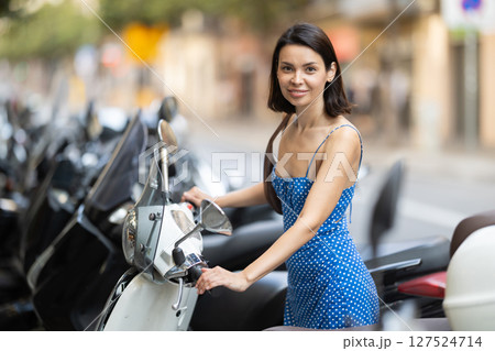 Young woman rents bike on city street 127524714