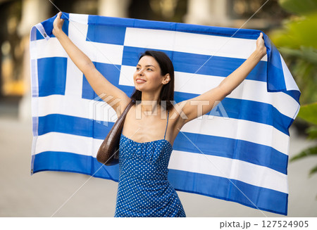 Young woman with Greek flag on city street Young woman with Greek flag on city street 127524905