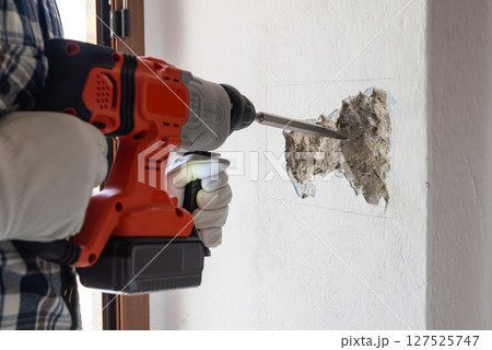 Carpenter electrician working with demolition hammer. Electricity. Carpenter electrician working with demolition hammer. Electricity. 127525747