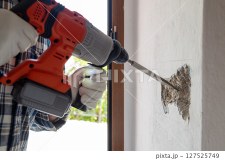 Carpenter electrician working with demolition hammer. Electricity. Carpenter electrician working with demolition hammer. Electricity. 127525749
