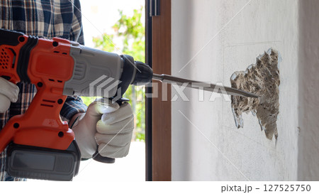 Carpenter electrician working with demolition hammer. Electricity. Carpenter electrician working with demolition hammer. Electricity. 127525750