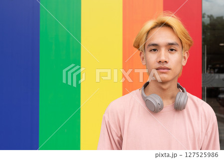 Handsome gay man portrait against pride rainbow background Handsome gay man portrait against pride rainbow background 127525986