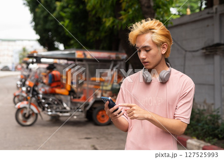 Young man tourist in Thailand ordering taxi with mobile phone 127525993