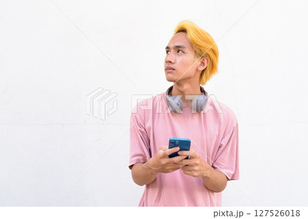 Man using smartphone against white wall 127526018