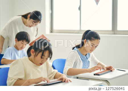 そろばんを教わる小学生 127526041
