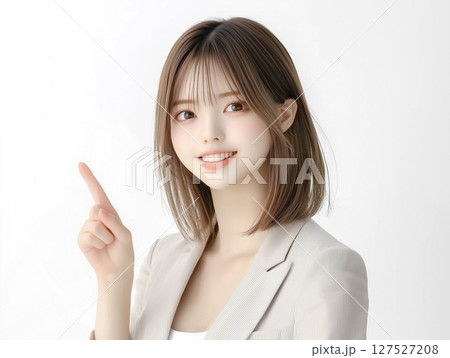 笑顔で上を指差す若い女性。案内、注目、視線誘導に最適な人物素材。白背景 127527208