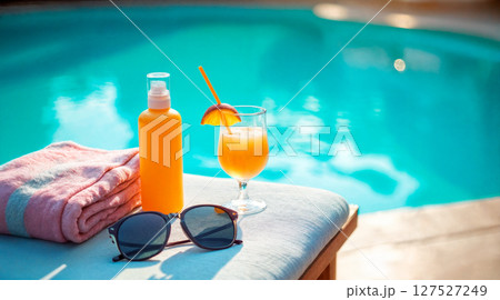 Closeup of towel and black protective sunglasses, goggles, fresh orange juice smoothie cocktail 127527249