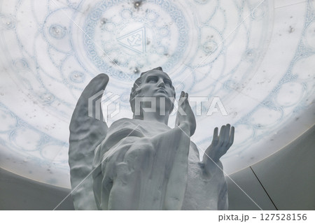 White Marble Angel Statue Praying Beneath Ornate Stained Glass Dome Inside Sacred Church 127528156