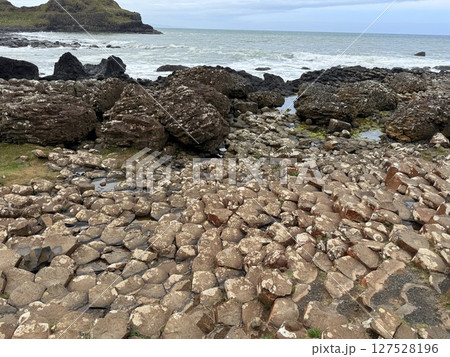 Giant's Causeway is a UNESCO World Heritage Site on Northern Ireland's Antrim Coast, famous for hexagonal stones by volcanic activity and beautiful coast. 127528196