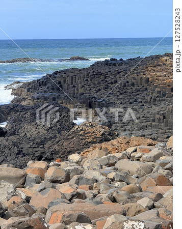 Giant's Causeway is a UNESCO World Heritage Site on Northern Ireland's Antrim Coast, famous for hexagonal stones by volcanic activity and beautiful coast. 127528243
