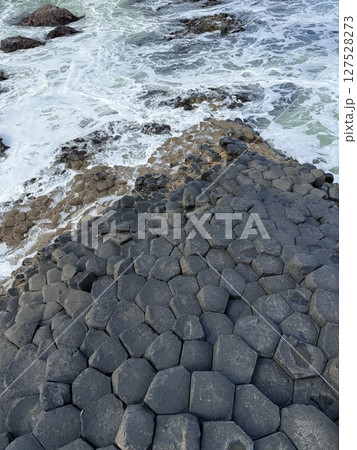Giant's Causeway is a UNESCO World Heritage Site on Northern Ireland's Antrim Coast, famous for hexagonal stones by volcanic activity and beautiful coast. 127528273