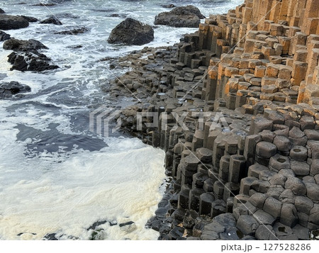Giant's Causeway is a UNESCO World Heritage Site on Northern Ireland's Antrim Coast, famous for hexagonal stones by volcanic activity and beautiful coast. 127528286