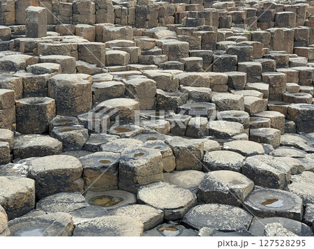 Giant's Causeway is a UNESCO World Heritage Site on Northern Ireland's Antrim Coast, famous for hexagonal stones by volcanic activity and beautiful coast. 127528295