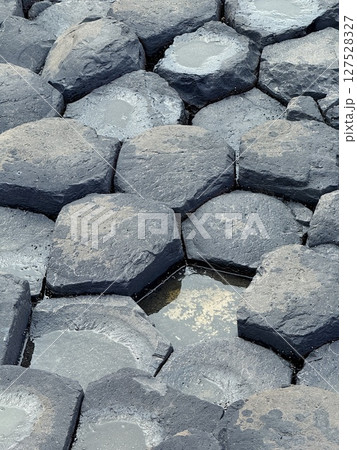 Giant's Causeway is a UNESCO World Heritage Site on Northern Ireland's Antrim Coast, famous for hexagonal stones by volcanic activity and beautiful coast. 127528327