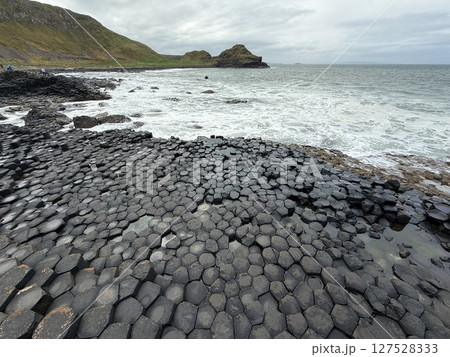 Giant's Causeway is a UNESCO World Heritage Site on Northern Ireland's Antrim Coast, famous for hexagonal stones by volcanic activity and beautiful coast. 127528333