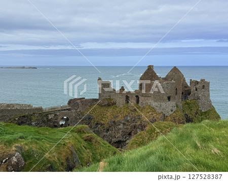 Dunluce Castle, perched on Northern Ireland's rugged Antrim Coast, showcases dramatic medieval ruins against windswept cliffs. Its weathered stone walls and sea views evoke history and mystery, ideal Dunluce Castle, perched on Northern Ireland's rugged Antrim Coast, showcases dramatic medieval ruins against windswept cliffs. Its weathered stone walls and sea views evoke history and mystery, ideal 127528387