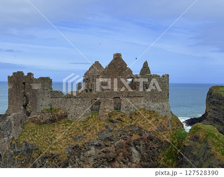 Dunluce Castle, perched on Northern Ireland's rugged Antrim Coast, showcases dramatic medieval ruins against windswept cliffs. Its weathered stone walls and sea views evoke history and mystery, ideal Dunluce Castle, perched on Northern Ireland's rugged Antrim Coast, showcases dramatic medieval ruins against windswept cliffs. Its weathered stone walls and sea views evoke history and mystery, ideal 127528390