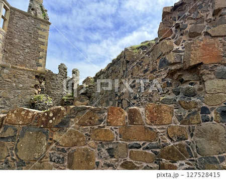 Dunluce Castle, perched on Northern Ireland's rugged Antrim Coast, showcases dramatic medieval ruins against windswept cliffs. Its weathered stone walls and sea views evoke history and mystery, ideal Dunluce Castle, perched on Northern Ireland's rugged Antrim Coast, showcases dramatic medieval ruins against windswept cliffs. Its weathered stone walls and sea views evoke history and mystery, ideal 127528415