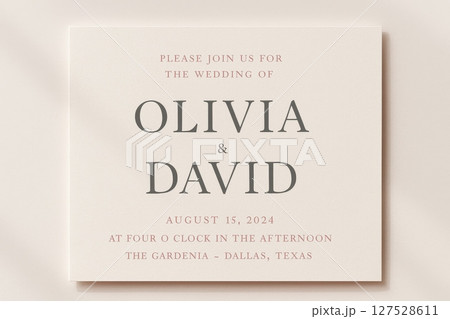 Wedding invitation card with elegant typography on soft neutral background announcing Olivia and David ceremony details 127528611