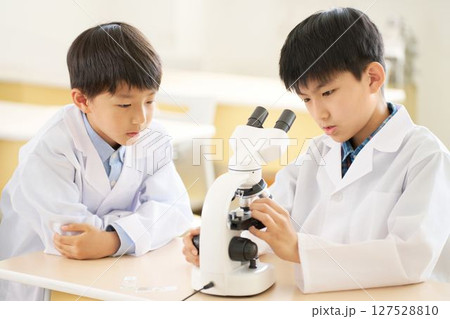 顕微鏡をのぞく白衣の小学生 127528810