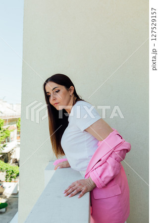 Beautiful fashion woman in white clothes and pink jacket on light background Beautiful fashion woman in white clothes and pink jacket on light background 127529157