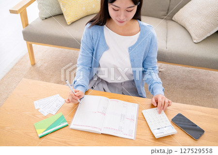 家計簿をつける若い女性 家計簿をつける若い女性 127529558