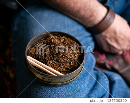 Preparing rolled cigarettes with dried tobacco. 127530290