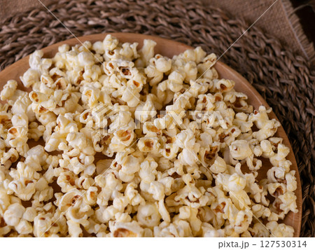 Butter salted popcorn on wooden table. 127530314