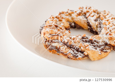 Brezel handcrafted sweet, pastry delicious snack, on white plate board, selective focus Brezel handcrafted sweet, pastry delicious snack, on white plate board, selective focus 127530996
