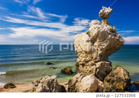 Rocks and stones of unusual bizarre shape on the sandy seashore at clear day 127531008