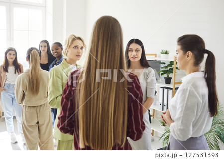 Group of smiling diverse women standing together in bright room and talking in friendly atmosphere. Group of smiling diverse women standing together in bright room and talking in friendly atmosphere. 127531393