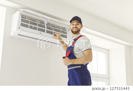 Portrait Of Happy Technician Conducting Air Conditioner Inspection At Home 127531445