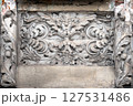 A detailed decorative relief carving on a wall, intricate floral and scroll motifs. Capturing the beauty of historic craftsmanship with an aged and weathered charm, the artistry of the past. 127531486