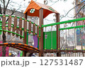 Vibrant children's playground equipment featuring climbing elements, bridges, and slides, offering fun and adventure within a dynamic urban area setting. 127531487