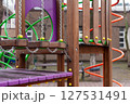 Colorful playground equipment made from wood and metal, featuring vibrant ropes and beams. The outdoor detailed architectural craftsmanship designed for children's playful activities. 127531491