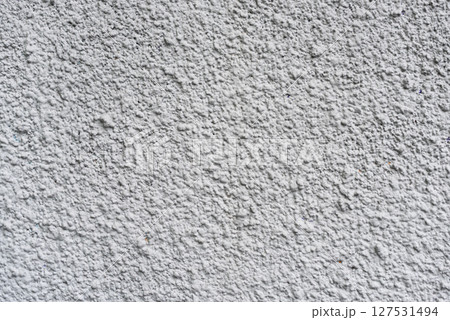 Rough white textured wall provides a detailed closeup of its uneven surface, suitable for backgrounds or design work. Unique structure and simplicity, it's ideal for creative projects 127531494