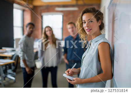 A woman is standing in front of a whiteboard with a pen in her hand A woman is standing in front of a whiteboard with a pen in her hand 127531814