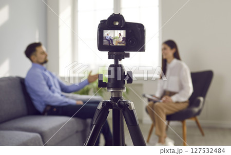 Close up photo of professional camera recording live podcast video interview of two bloggers. Close up photo of professional camera recording live podcast video interview of two bloggers. 127532484