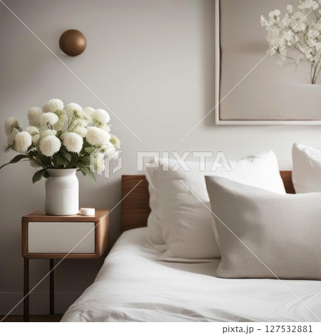 Minimalist bedroom with cozy vibes and a touch of nature; white flowers add serenity. 127532881