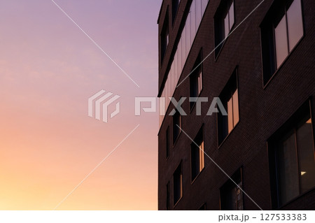 Sunset glow reflecting off a modern brick building in an urban setting 127533383