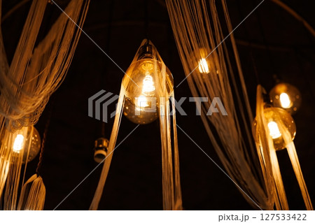 Unique hanging lights create a warm ambiance in an artistic space, enhancing relaxation and creativity 127533422