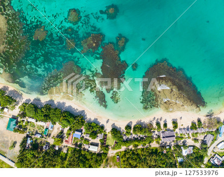 Island with a sandy white beach with palm trees and azure water and coral reef. Cagwait White Beach. Mindanao, Philippines. Travel and summer concept. 127533976