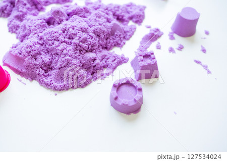 Purple kinetic sand with molded shapes on white surface Purple kinetic sand with molded shapes on white surface 127534024