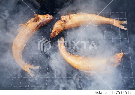 Smoked fish on the grill with smoke 127535519