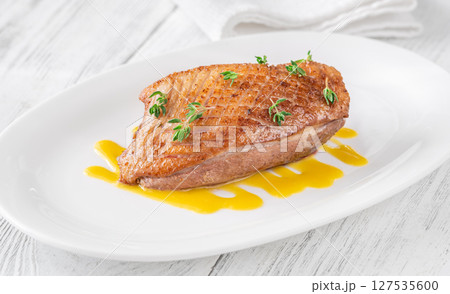Whole Crispy Duck Breast on Mustard Lemon Honey Sauce in White Plate 127535600